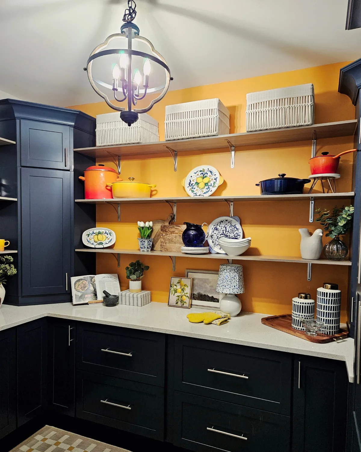 Pantry with saffron-yellow walls, open shelving, a glass lantern pendant and navy cabinets
